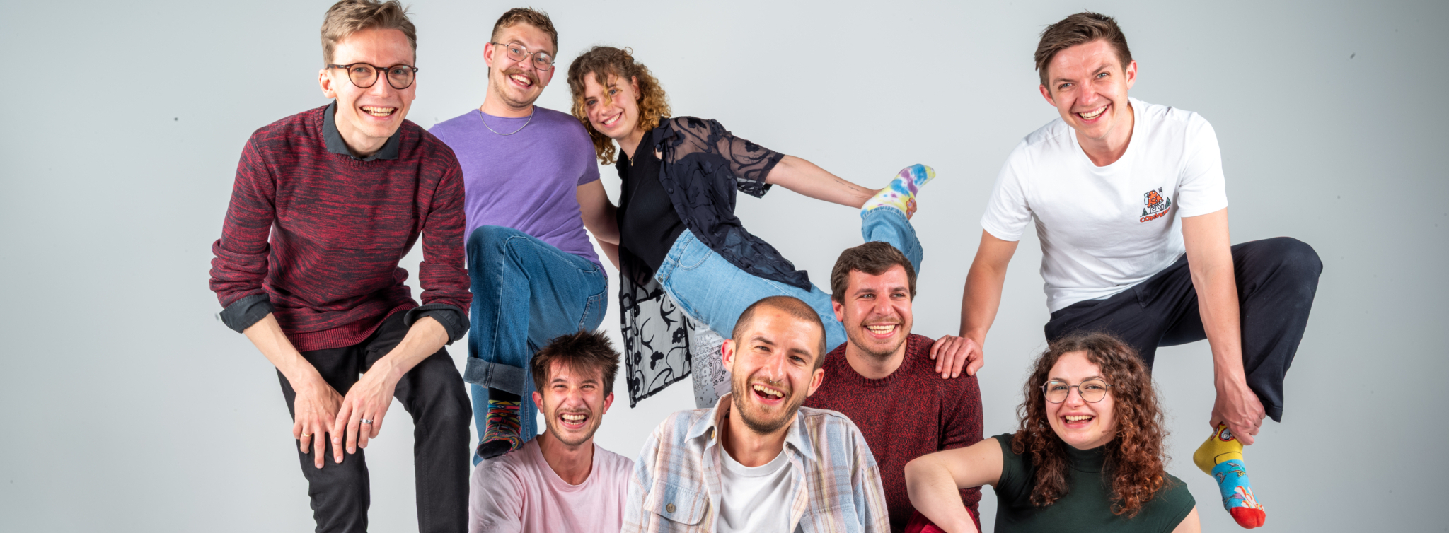 Die Band Elias und die coolen Socken posiert lachend in bunten Socken für ein gemeinsames Gruppenfoto.